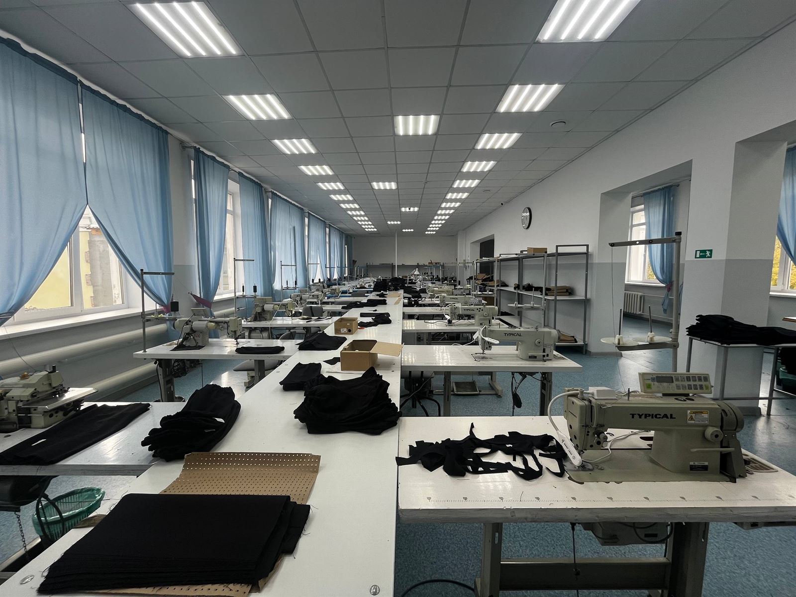 Швейный цех после ремонта: длинные ряды столов и большие окна